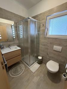 a bathroom with a shower and a toilet and a sink at Apartman Aloe in Mali Lošinj +21 photos