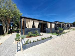 a building with curtains and plants in front of it at MobileHome Serdar in Sveti Filip i Jakov