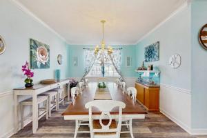a dining room with a long table and white chairs at Wedgefield -- 1 Wedgefield in Ocean View
