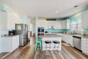 a kitchen with white cabinets and blue walls at Wedgefield -- 1 Wedgefield in Ocean View +27 photos