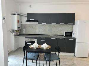 a kitchen with a table with chairs and a refrigerator at Apartment complex in Roşu +9 photos