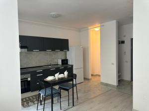 a kitchen with a table and chairs in a room at Apartment complex in Roşu