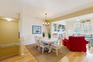 a dining room with a table and a red couch at Bear Trap Dunes - 214H October Glory Ave in Ocean View