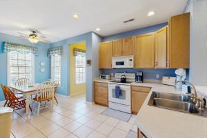 a kitchen with a sink and a table with a dining room at Bear Trap Dunes - 214H October Glory Ave in Ocean View
