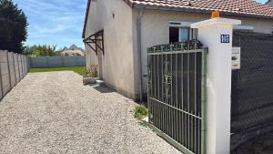 a gate in front of a house with a fence at Maison 2 chambres avec jardin et parking privatif in Saran +1 photo