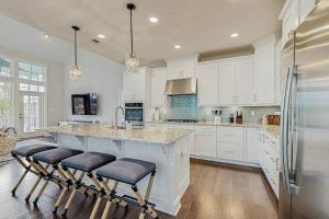 a kitchen with white cabinets and a large island with bar stools at Marlin Chase --- 30347 Bermuda Dr in Ocean View