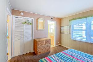 a bedroom with a bed and a closet and a window at Sunspot Condo --- 2 McKinley Ave, Unit 103 in Dewey Beach