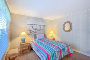a bedroom with a bed and two lamps and a mirror at Sunspot Condo --- 2 McKinley Ave, Unit 103 in Dewey Beach
