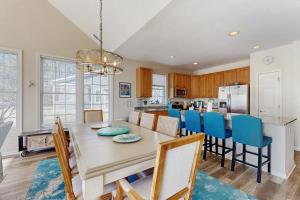 a kitchen and dining room with a table and blue chairs at Bear Trap Dunes - 81 Tulip Poplar in Ocean View
