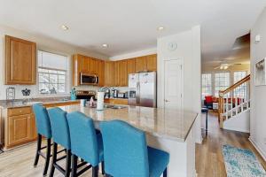 a kitchen with a island with blue bar chairs at Bear Trap Dunes - 81 Tulip Poplar in Ocean View