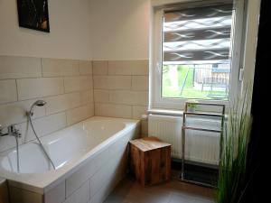 a bath tub in a bathroom with a window at Ferienhaus Fichtelberg in Kurort Oberwiesenthal +79 photos
