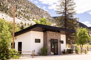 a small white building with a mountain in the background at NEW! Modern Cabin Tiny Home at Cliffside #1 in Orderville