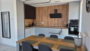 a kitchen with a wooden table and chairs and a kitchen with a counter at Apartman Bartimej 3A in Bobrów