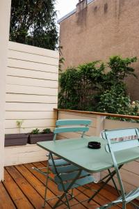 a green table and a chair on a patio at Osmose Dijon in Dijon
