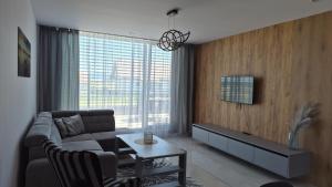a living room with a couch and a table at Apartman Bartimej 3A in Bobrów