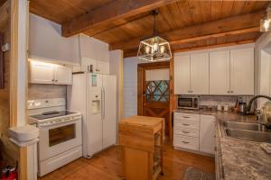 a kitchen with white appliances and a wooden ceiling at Have No Regrets in Blowing Rock