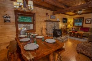 a living room with a wooden table and a fireplace at Have No Regrets in Blowing Rock +16 photos