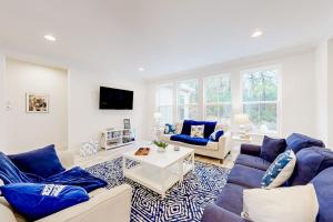a living room with blue couches and a tv at The Estuary - 26643 Weathervane Way in Frankford
