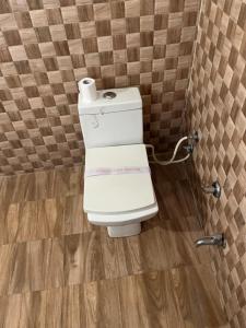 a toilet with a roll of toilet paper on it at Hotel CHINTPURNI JMC in Bharwain