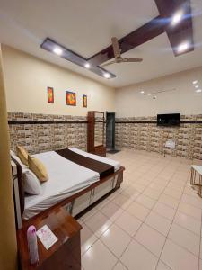 a bedroom with a bed and a flat screen tv at Hotel CHINTPURNI JMC in Bharwain +1 photo