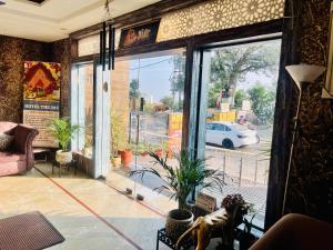 a living room with a large window with a potted plant at Hotel CHINTPURNI JMC in Bharwain