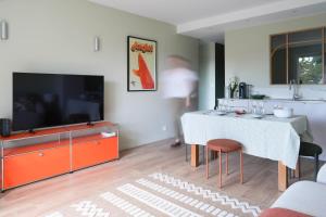 a living room with a white table and a television at Chiberta Ocean & Golf Suite in Anglet
