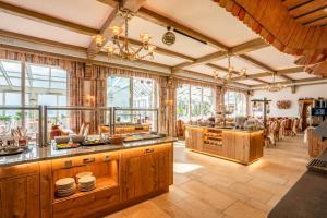 a large kitchen with wooden cabinets and windows at Hotel Glocknerhof in Berg im Drautal