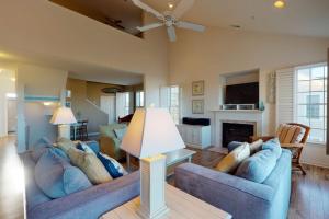 a living room with two blue couches and a fireplace at Bear Trap Dunes - 126B October Glory Ave in Ocean View