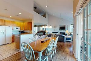 a kitchen and dining room with a wooden table and chairs at Bear Trap Dunes - 126B October Glory Ave in Ocean View