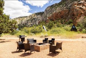a fire pit with chairs and a grill in a field at NEW! Cozy Container Home at Cliffside #3 in Orderville +10 photos