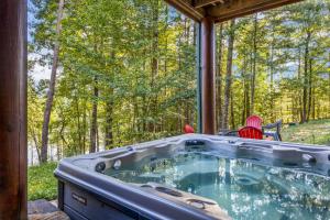 a jacuzzi tub on a porch in the woods at Lake Haven Lodge in Wilkesboro