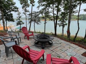 a patio with chairs and a fire pit next to a lake at Lake Haven Lodge in Wilkesboro