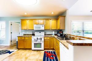 a kitchen with wooden cabinets and a white stove top oven at Forest Reach --- 33720 Chatham Way in Frankford