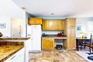 a kitchen with wooden cabinets and a white refrigerator at Forest Reach --- 33720 Chatham Way in Frankford