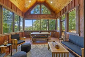 a screened in porch with a table and chairs at Chimney Island in Blowing Rock
