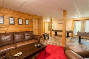a living room with a leather couch and a pool table at A Beary Good Time in Boone +30 photos