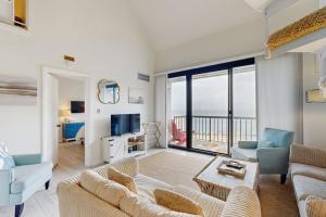 a living room with a couch and a television at Sea Colony - 902 Georgetowne House in Bethany Beach +42 photos