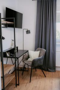 a desk and a chair in a room with a window at Apartment am Berg in Grünstadt