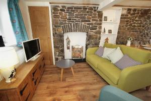 a living room with a green couch and a tv at 1 Bed in Mumbles oc-hh1210 in The Mumbles