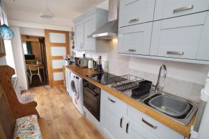a kitchen with white cabinets and a sink at 1 Bed in Mumbles oc-hh1210 in The Mumbles