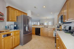 a kitchen with a stainless steel refrigerator and wooden cabinets at Sea Colony - 55006 Pine View Rd in Bethany Beach +32 photos