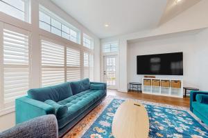 a living room with a blue couch and a tv at Marlin Chase---30453 Madeira Ln in Ocean View