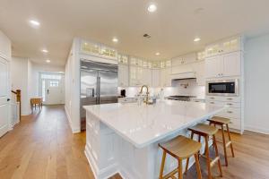 a kitchen with white cabinets and a large white island at Marlin Chase---30453 Madeira Ln in Ocean View +20 photos
