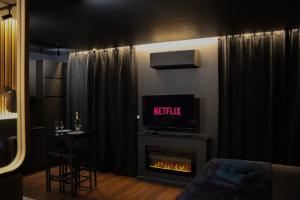 a living room with a fireplace and a tv at Osmose Dijon in Dijon