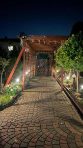 a brick walkway with a wooden bridge at night at Noclegi U Waldiego in Starachowice