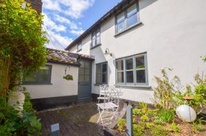 an exterior view of a white house with chairs at 2 Bed in Walsham-le-Willows oc-gabpla in Walsham le Willows