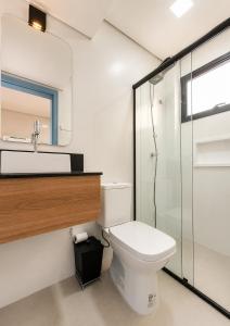 a bathroom with a toilet and a glass shower at Pousada Soul Papagaio - lofts completos a 30 metros do mar in Palhoça +34 photos