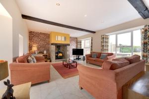 a living room with two couches and a tv at High Mill in Beadnell