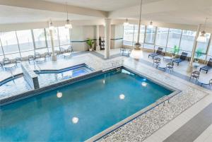 a pool in a building with chairs and tables at Hyatt Regency Niagara Falls Fallsview in Niagara Falls