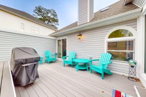 a wooden deck with blue chairs and a table at Salt Pond --- 494 Bethany Loop in Bethany Beach